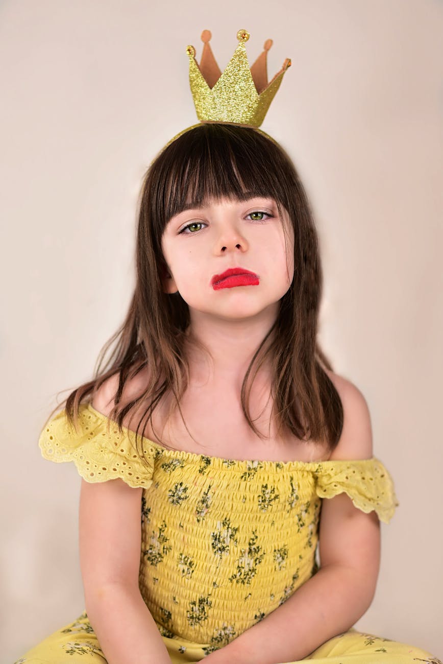 a sad little girl in yellow floral dress